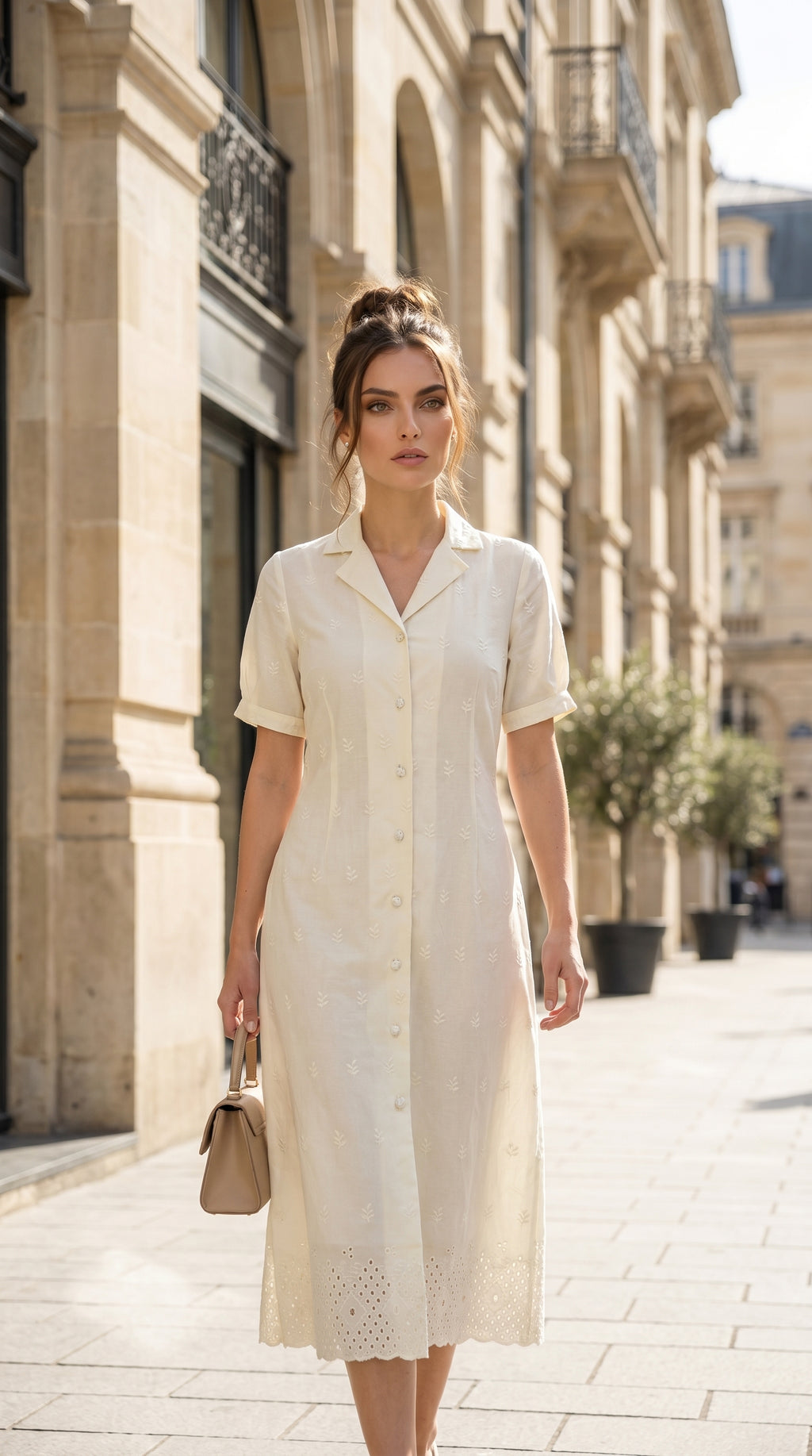 Woman in a white dress walking down a sunlit street.