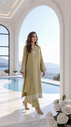 Woman in a light green traditional outfit standing by a pool with a scenic view.