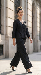 Woman in a black outfit walking on a city street.