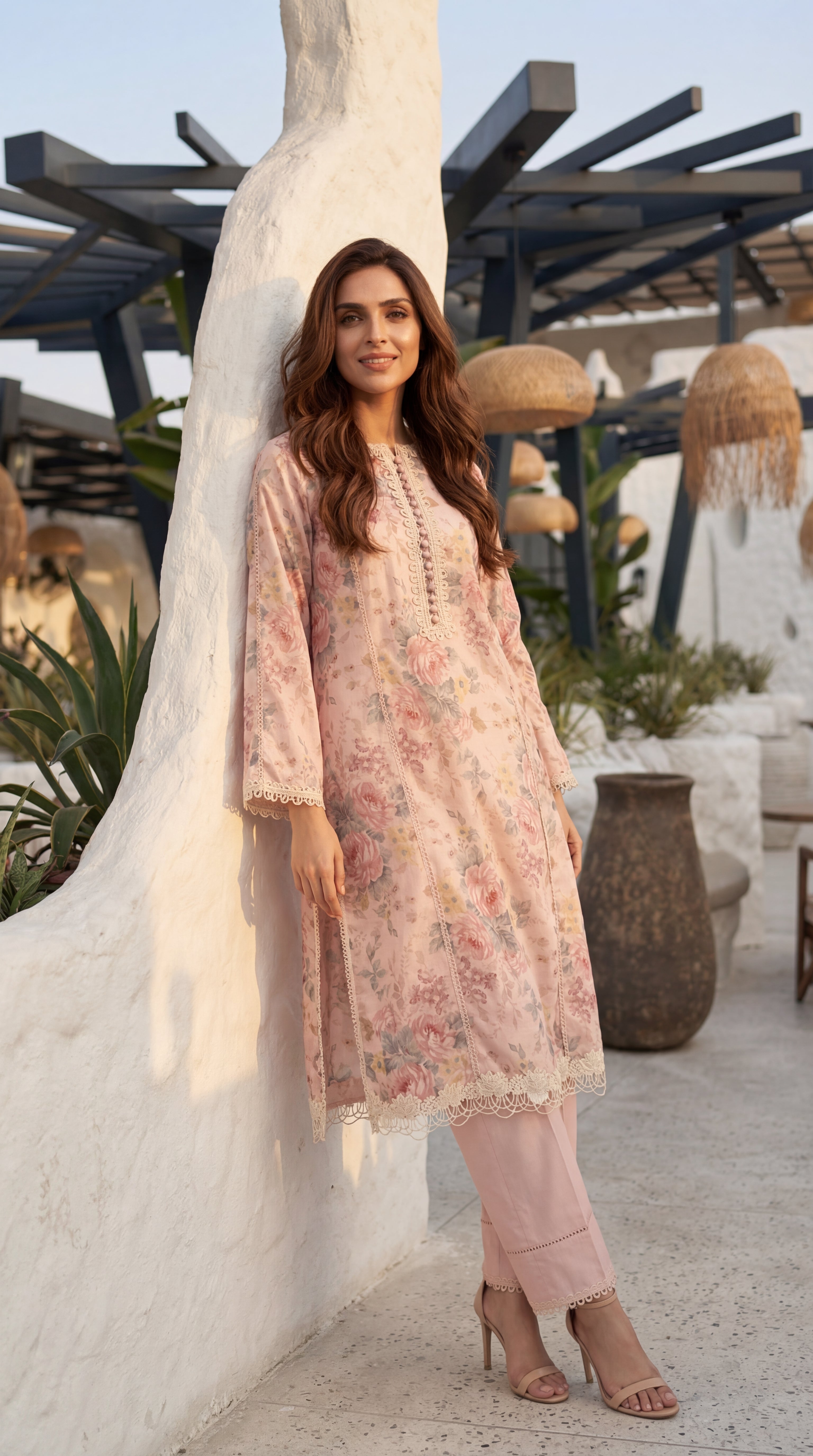 Woman in a floral dress standing outdoors with decorative elements in the background