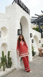 Woman in a red outfit standing in front of a white architectural structure with 'Mocca' cafe