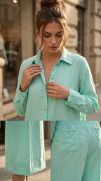 Woman wearing a mint green outfit with a matching jacket and pants on a city street.