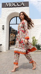 Woman in a floral dress with orange accents standing in front of a building with 'MOCCA' CAFE BAKU.