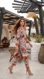 Woman in a floral outfit standing in an outdoor setting with a modern architectural design.