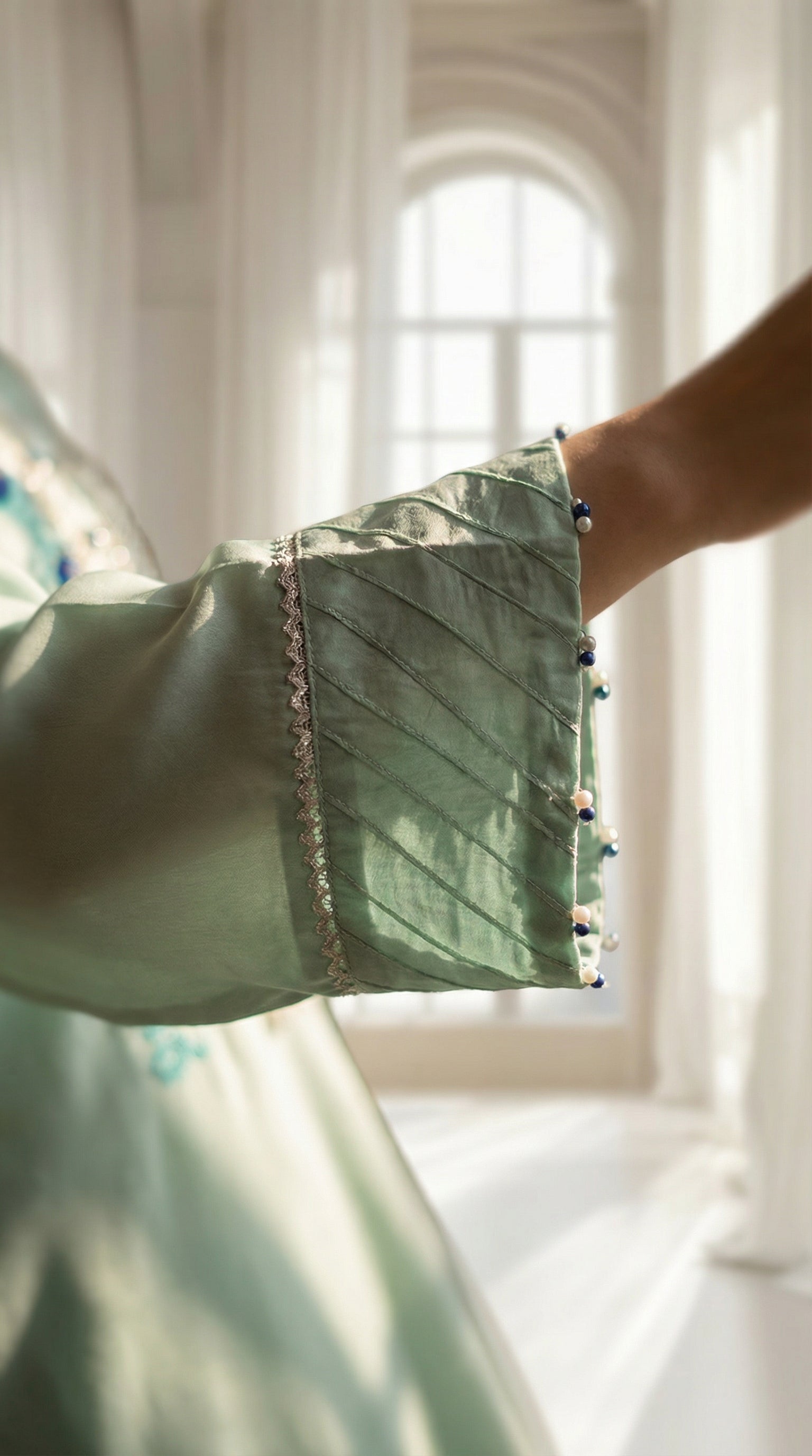 Green garment with intricate detailing in a softly lit room