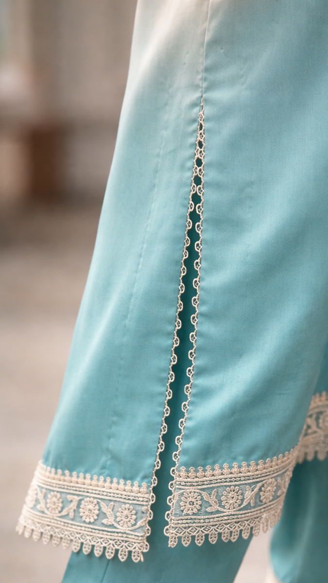 Light blue pants with white embroidery on a blurred background