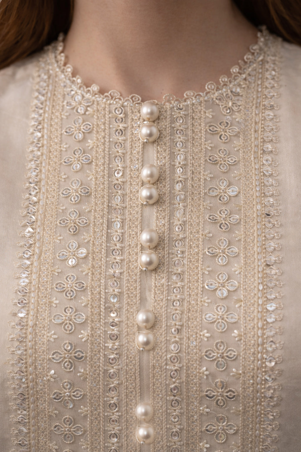 Close-up of a beaded and embroidered garment with pearls