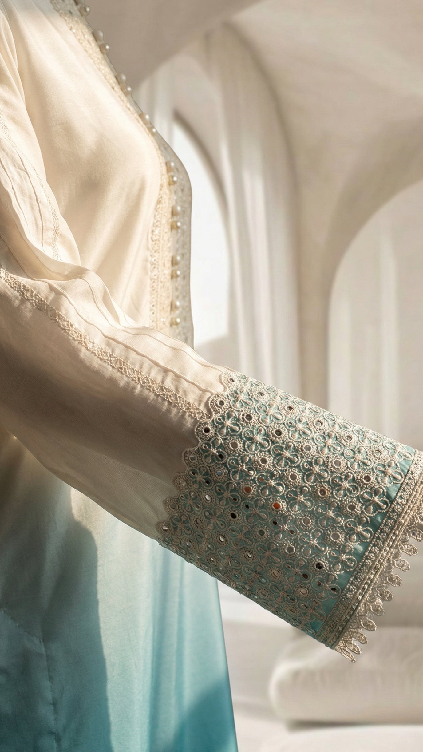 Close-up of a garment with intricate embroidery and a soft, blurred background