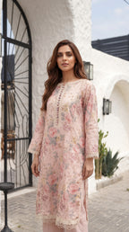 Woman wearing a floral dress standing in front of a white archway.