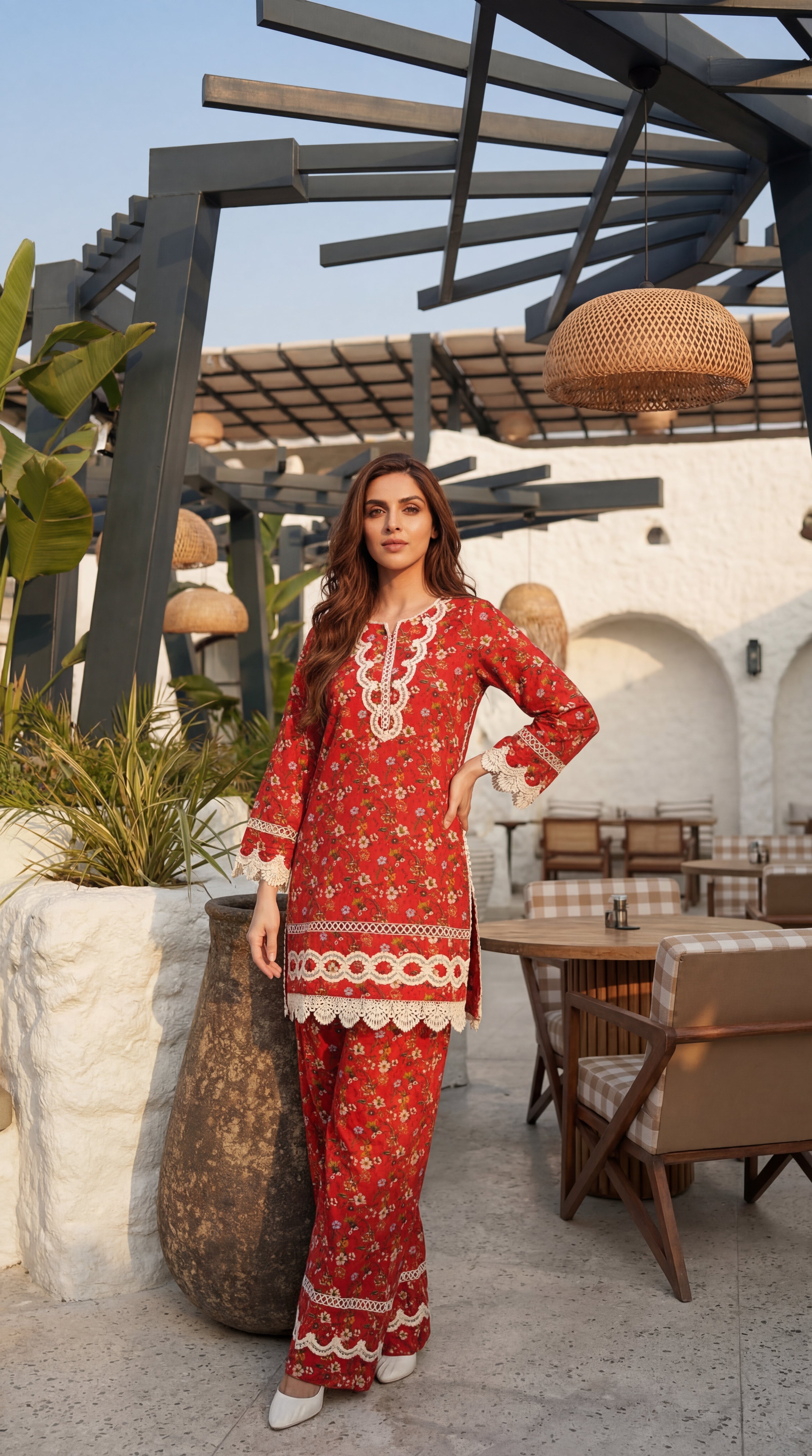 Woman in a red outfit with white embroidery standing outdoors.