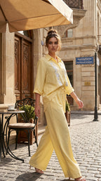 Woman in a yellow outfit walking on a street with a cafe in the background